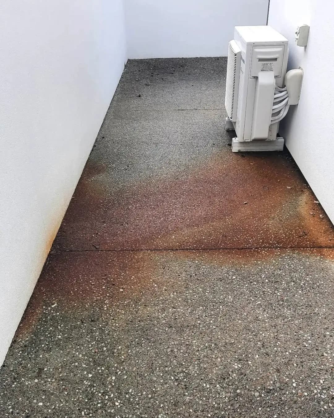 Stained and discolored concrete surface before acid washing treatment in Queenstown