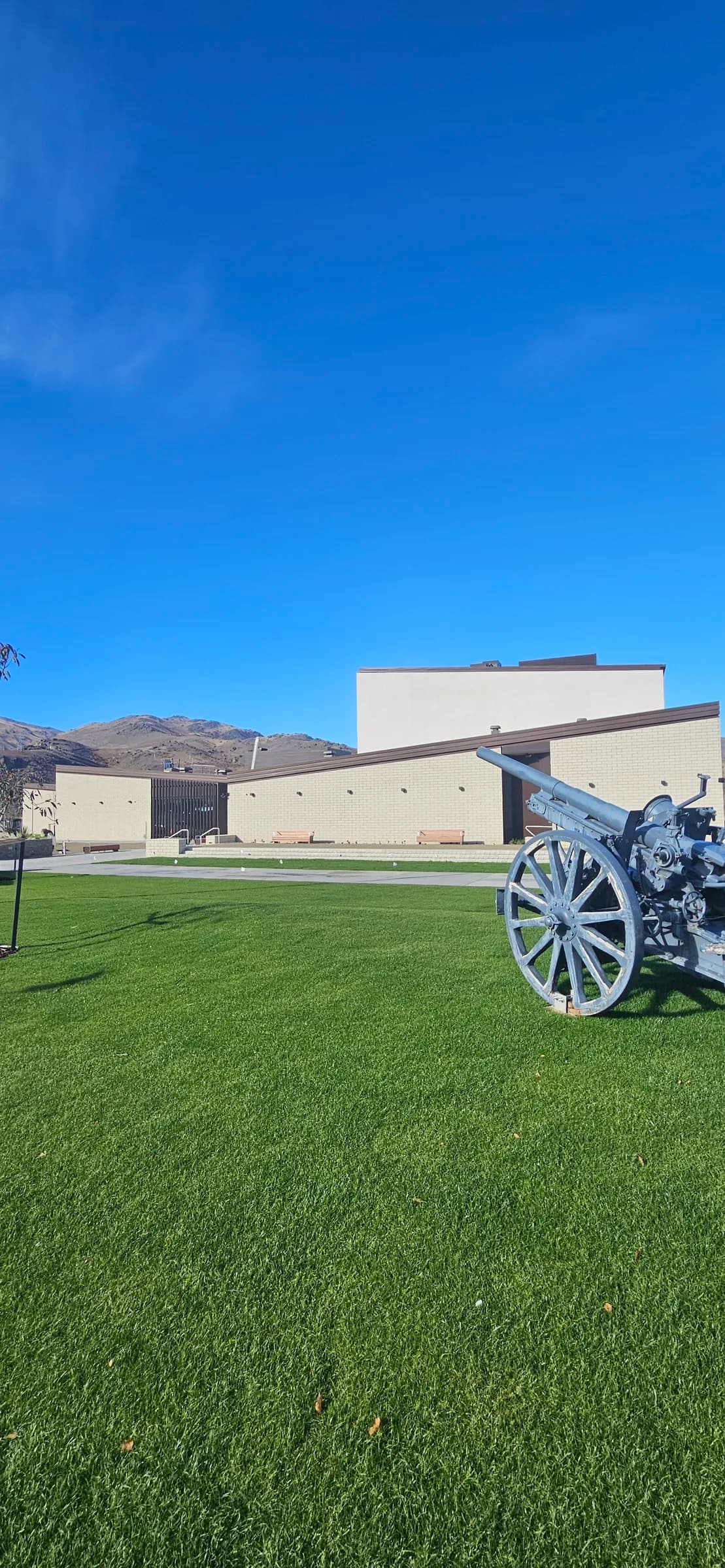 WWI artillery memorial on the lawn beside the restored Cromwell Memorial Hall