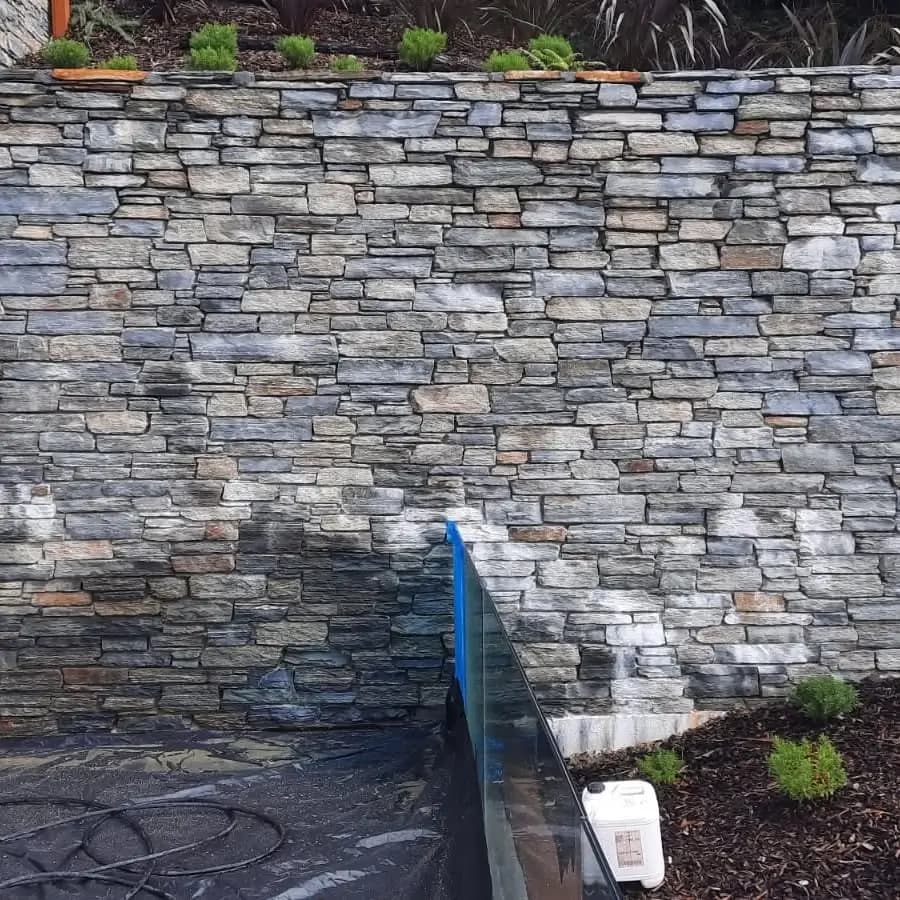 Severe efflorescence on concrete wall before treatment in Queenstown