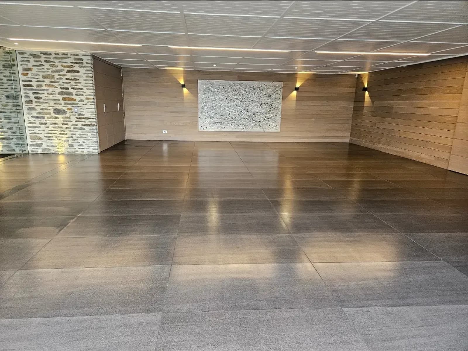 Same ceramic tile floor cleaned to an even satin finish under the wall-wash lighting, Wanaka