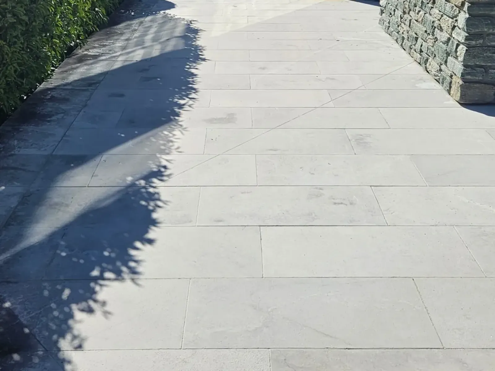 Same limestone paving restored along the schist boundary wall, Wanaka